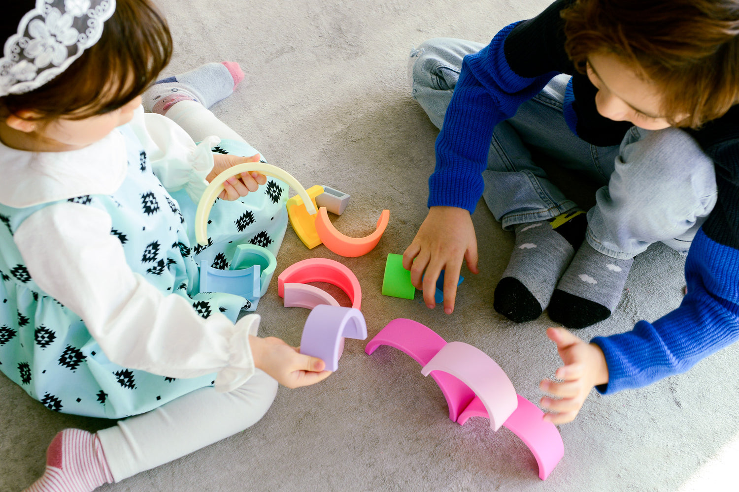 Two kids playing with silicone rainbow toys